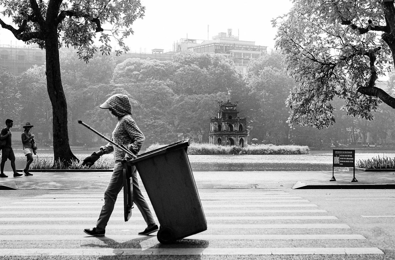 Worker moving a trash bin